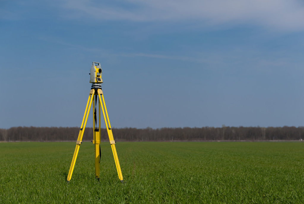 Yellow surveying machine placed in an open field