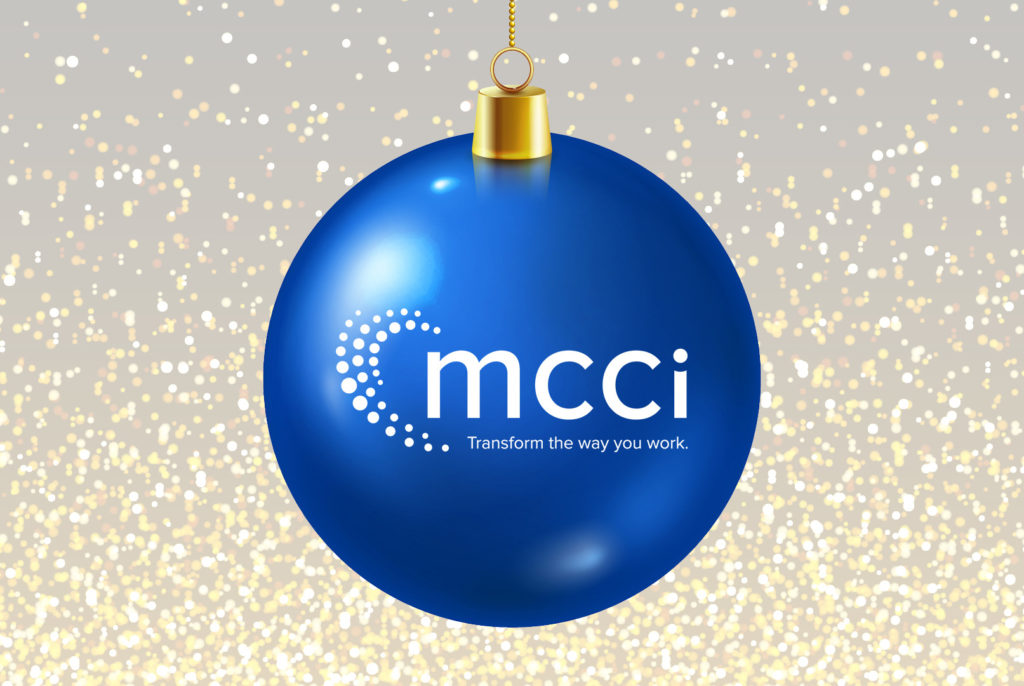 blue ornament with MCCI's new logo and tagline surrounded by glitter