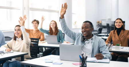 Portrait of smiling diverse people raising hands at seminar stock photo