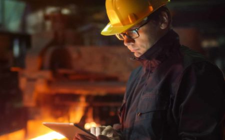 construction worker reviewing blueprints on tablet