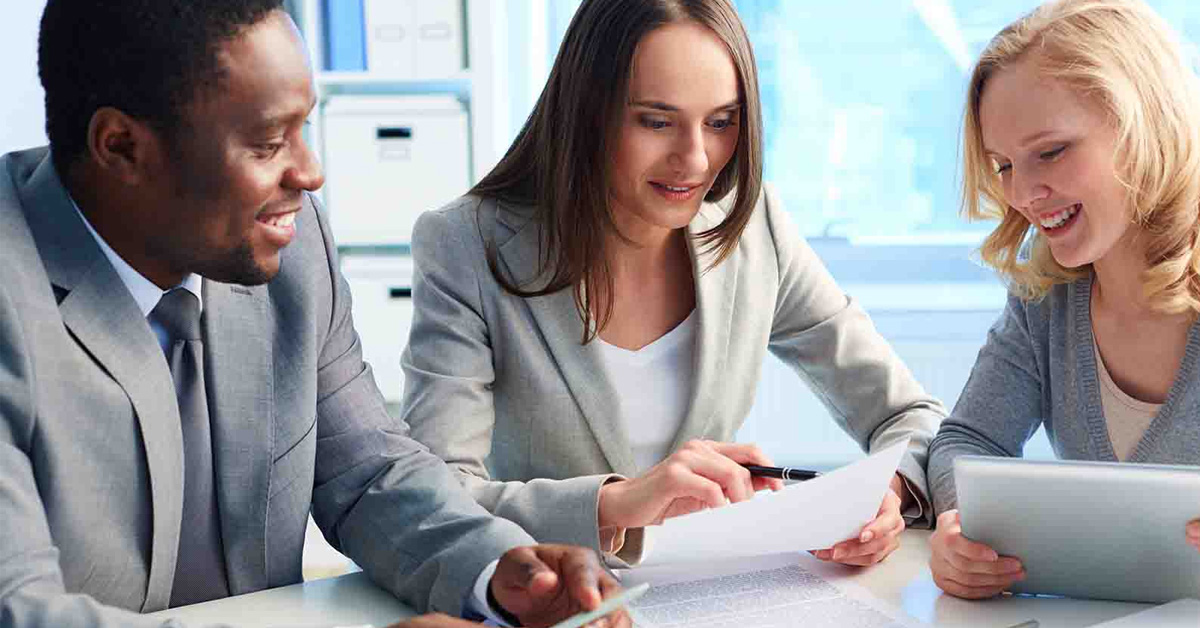 happy people sitting at table looking over paperwork