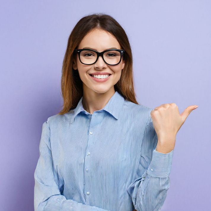 Happy young smiling professional business woman wearing blue shirt looking at camera pointing finger away at copy space