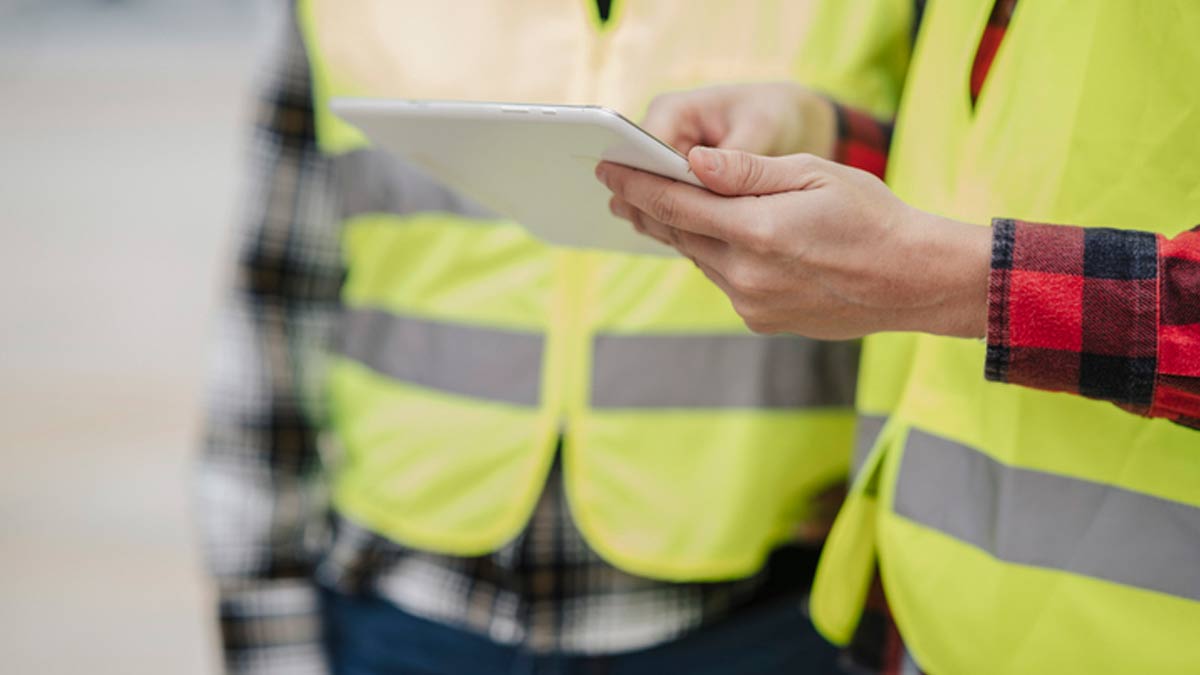 Close-up of Construction Workers Using Tablet on Site
