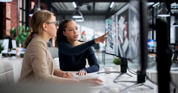 employees reviewing data on a screen