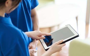 Caregiver viewing materials on tablet stock photo