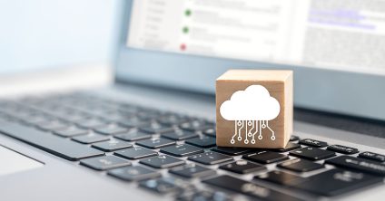 cloud symbol on wooden block on laptop keyboard stock photo