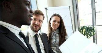 team looking over paperwork in folder together