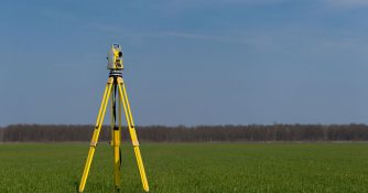 Yellow surveying machine placed in an open field